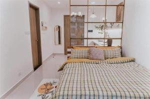 河内Yody Homestay Ocean Park, Gia Lâm, Hà Nội的一间卧室配有一张大床和一张铺着条纹毯子