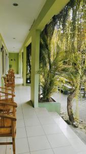 库塔PURNAMA HOUSE KUTA的一间拥有棕榈树壁画的餐厅的大堂