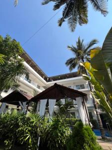 曼德姆La Vera Boutique Hotel, Mandrem的一座带遮阳伞和棕榈树的大型建筑