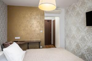 特尔纳瓦Hotel MAXPLAZA的一间卧室配有一张床、一张桌子和一盏灯