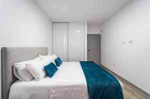 圣克鲁斯Guesthouse Olival的一间卧室配有白色床和蓝色枕头