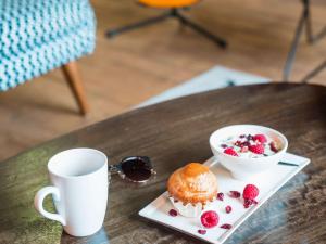 布拉尼亚克图卢兹机场宜必思尚品酒店的桌子上放着咖啡、松饼和一碗浆果