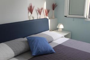 切塔拉Casa Azzurra的一间卧室配有一张带蓝色枕头的床