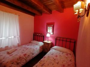 ArrésHotel Rural Casa Dera Hont的红色墙壁客房的两张床