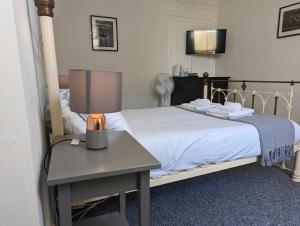 多佛尔Dover Town Rooms - Short Lets & Serviced Accommodation - Dover的一间卧室配有一张床和一张带台灯的桌子