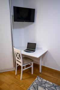 诺维萨德Sky Apartments Novi Sad的一张坐在白色书桌上的笔记本电脑和椅子