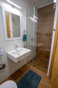 诺维萨德Sky Apartments Novi Sad的白色的浴室设有水槽和淋浴。
