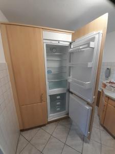 大格勒瑙TannenQuartier - Ihr Ferienhäuschen的厨房里空着冰箱,门开着