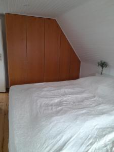 大格勒瑙TannenQuartier - Ihr Ferienhäuschen的卧室配有一张白色大床和木制床头板