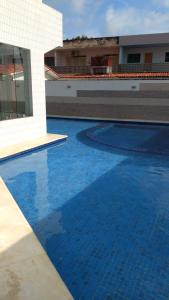 普拉亚多斯卡内罗斯Praia dos Carneiros Flat Hotel Lindo Apto 302的一座大型蓝色游泳池,位于大楼旁边