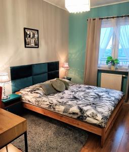 马佐夫舍地区新庄园2-Room Apartment的一间卧室配有一张床、一张桌子和一个窗户。