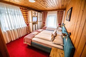 平茨高谷地霍勒尔斯巴赫KITZALPEN Pension的木制客房内的一间卧室配有一张大床
