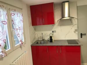 伊伦Apto. BLAIA的厨房配有红色橱柜、水槽和窗户
