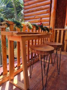 奥克萨潘帕Elfen hospedaje familiar的门廊上的木桌和两个凳子