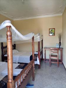 MasindiPross Residence的一间卧室设有两张双层床和一张桌子