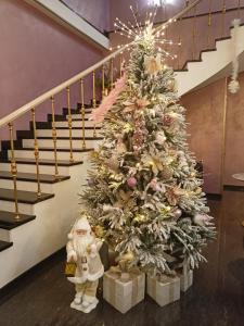 埃里温Nork Hotel的楼梯旁的圣诞树和礼物