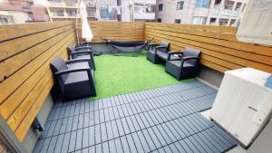 大阪难波波哩2号旅舍的阳台配有椅子,铺有绿色地板