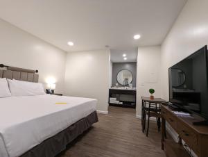 DunlapThe Honey Bee Motel的配有一张床和一台平面电视的酒店客房