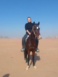 瓦迪拉姆Sunset Mountain的沙漠中骑马的女人