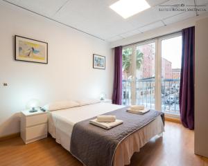 瓦伦西亚Suites Rooms Valencia的白色的卧室设有床和大窗户