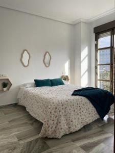 韦尔瓦Apartamento turístico La Joya的一间白色卧室,配有一张大床和两面镜子