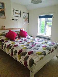 KintburyCharming Kintbury Cottage的卧室内的一张带粉红色枕头的大床