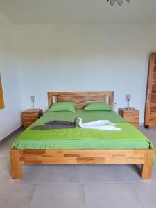 潘托皮芒MoonLight的一间卧室配有一张带绿色床单的木床。
