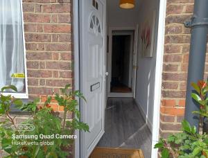 卢顿Salisbury House-Huku Kwetu Spacious 4 Bedrooms House- Sleeps 6 - Luton Town Centre的通往砖房的白色门