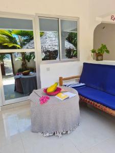 江比阿Ladha ya Zanzibar Boutique Guesthouse的客厅配有桌子和蓝色沙发