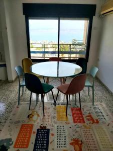 提比里亚turtle guesthouse- tiberias的窗户客房内的桌椅