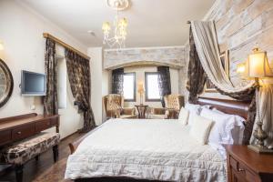 埃拉托克里昂埃尔瑟德斯精品酒店的一间卧室设有一张带石墙的大床