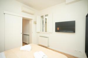 摩德纳Modena Centro Junior Suite的白色客房,墙上配有平面电视