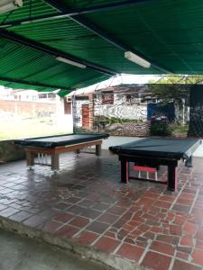 ChinácotaHotel La Casona的砖砌庭院的两张乒乓球桌