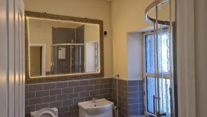 登比Braillen Suite- 2 bedroom with kitchenette and bathroom的一间带水槽、镜子和卫生间的浴室