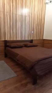 哈尔科夫Міні готель на Костюринському的卧室内的一张床铺,设有木墙
