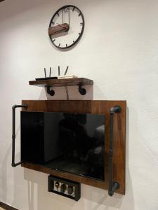 珍南海滩ZUSCH STUDIO的墙上的电视,墙上挂着时钟