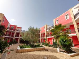 萨尔雷Estoril Hotel - Apartments的庭院中一排种有棕榈树的建筑