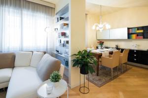 比萨Foscolo 25 Apartment的客厅配有白色的沙发和桌子