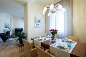 比萨Foscolo 25 Apartment的一间带桌椅和吊灯的用餐室