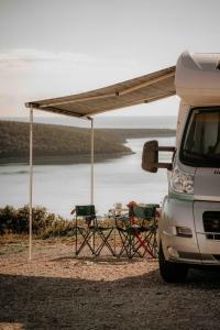 普拉Camper for 4 persons Istria的一辆面包车旁边的帐篷下一张桌子和椅子