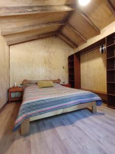 CurarrehueHabitación Establo de Caballos的木制天花板的客房内的一张大床
