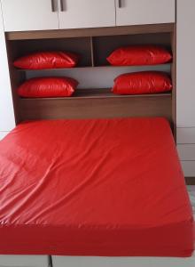 里约热内卢Apartamento encantador com vaga de garagem的红色的床和红色枕头