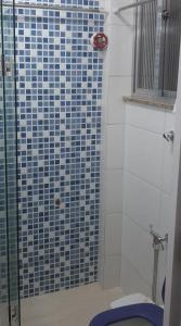 里约热内卢Apartamento encantador com vaga de garagem的浴室设有蓝色瓷砖淋浴和卫生间
