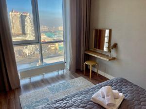 阿拉木图Шикарные апартаменты с прекрасным видом в лучшем районе的酒店客房设有一张床和一个大窗户
