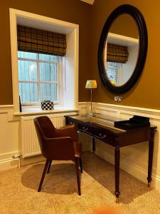 斯卡伯勒花冠馆乡村之屋餐厅酒店的一张桌子,椅子和镜子在房间内