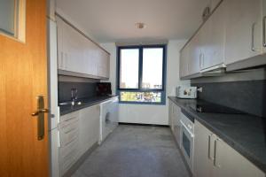 巴塞罗那巴塞罗那海景度假公寓的一间设有白色橱柜和窗户的大厨房