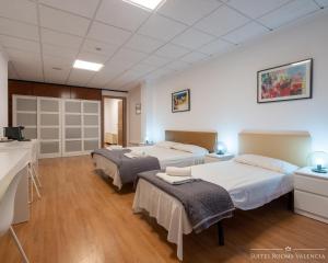 瓦伦西亚Suites Rooms Valencia的客房设有两张床和盥洗盆。
