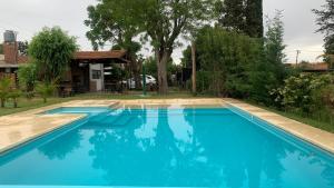洛博斯Altos de Empalme的一座大型蓝色游泳池,位于房子旁边
