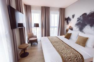弗莱堡Hotel Libertas elements pure的酒店客房带一张大床和一把椅子
