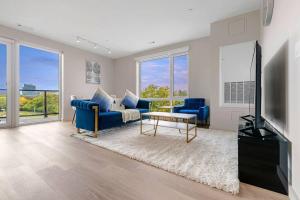 波士顿Luxurious&modern with balcony on the charles River的客厅配有蓝色的沙发和电视